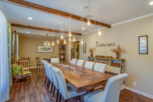 a dining room with a long table and white chairs at The Graycroft by Stay Local Nashville in Nashville