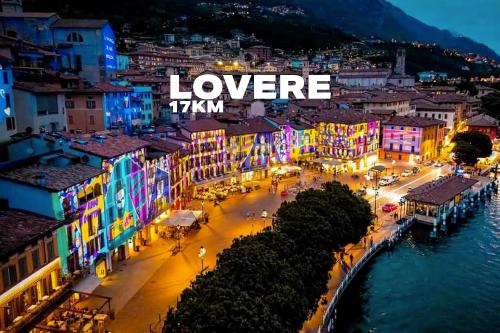 a city lit up at night with the words loverkm at La rocca - private Garden in Darfo