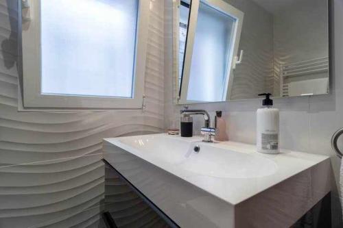 une salle de bain avec un lavabo blanc et une fenêtre dans l'établissement Ferrobús, à Zamora