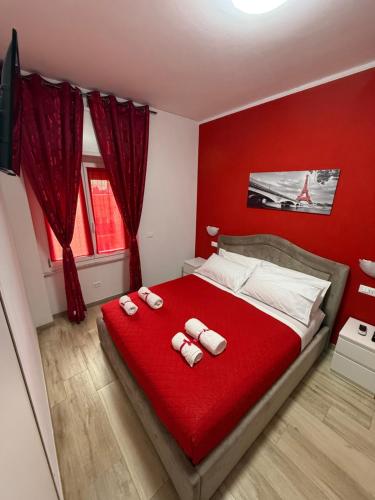 1 dormitorio rojo con 1 cama con 2 toallas en Alì Babà Rooms, en La Spezia