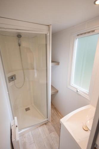 une salle de bain avec douche et lavabo dans l'établissement Camping les Chelles, à Olliergues