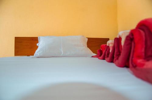 a bed with red blankets and a white pillow at HOTEL MAA MEVFOU Hmm in Yaoundé