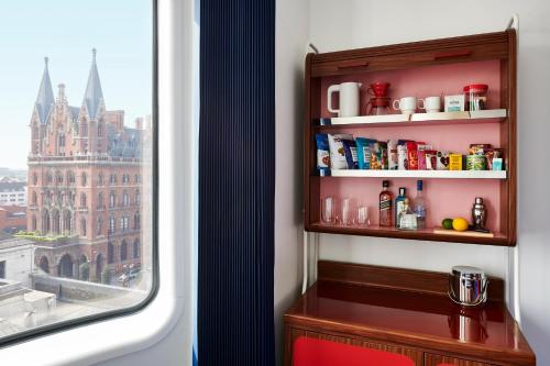 a room with a shelf with spices and a window at The Standard London in London