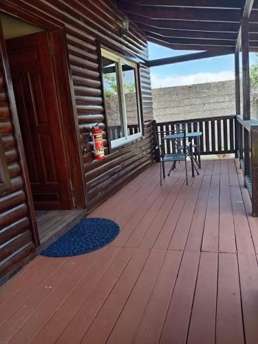 a wooden porch with a bench and a fire hydrant at Villas Palmerola Comayagua in El Coquito