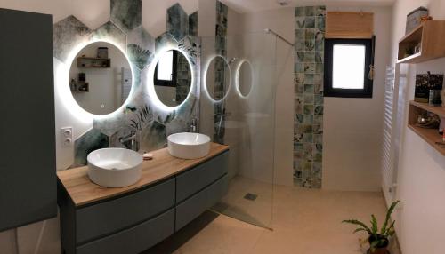 une salle de bain avec deux lavabos et deux miroirs dans l'établissement Villa with pool for 8 people, à Boissières