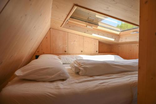 a bedroom with a bed in a wooden room at Tiny House Pioneer 1 - Salemer See in Salem