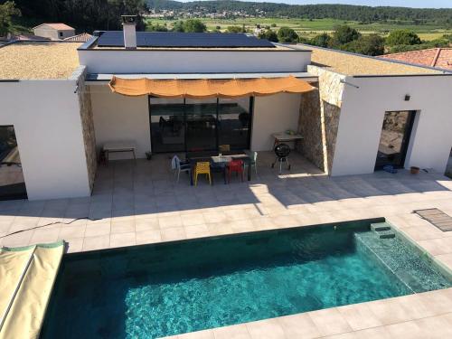 une maison avec une piscine à côté d'une terrasse dans l'établissement Villa with pool for 8 people, à Boissières
