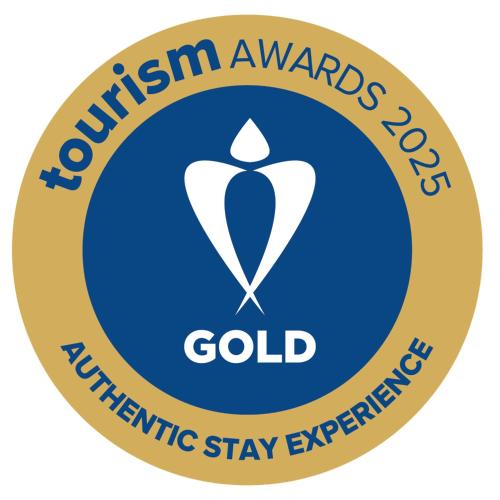 a yellow and blue circle with the words tourism awards gold identifier stay expensive at Bella Cisterna in Chios