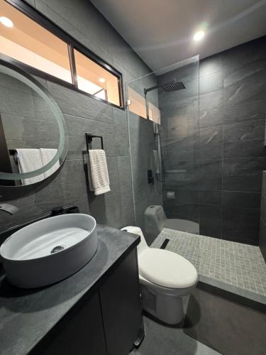 a bathroom with a sink and a toilet and a mirror at Ocean Dream Apartment E2-A3 in San Juan del Sur