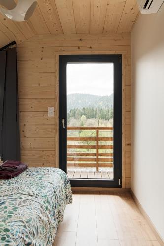une chambre avec un lit et une grande fenêtre dans l'établissement Chalet Abies Alba, à Gérardmer