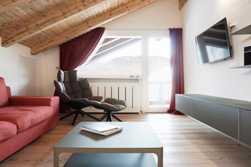 een woonkamer met een rode bank en een tafel bij CanguroProperties - Al Mas 1 in Cojana