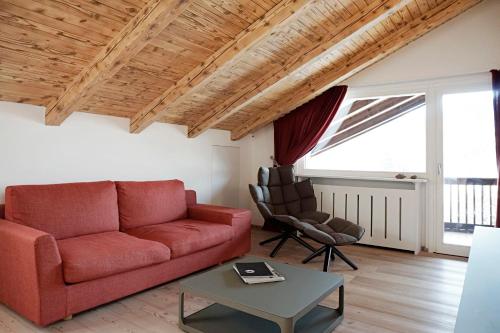 een woonkamer met een rode bank en een tafel bij CanguroProperties - Al Mas 1 in Cojana