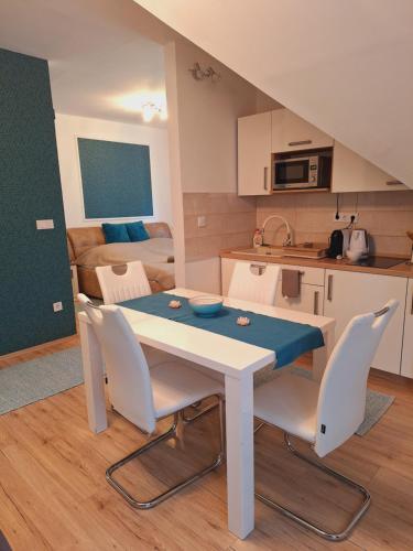a kitchen and dining room with a table and chairs at Égerliget Vendégház in Harkány