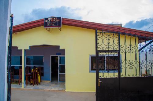 a yellow building with a sign on top of it at HOTEL MAA MEVFOU Hmm in Yaoundé