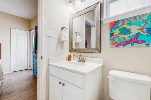 a bathroom with a white sink and a mirror at Tiki House in Corpus Christi