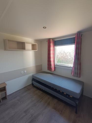 une petite pièce avec un lit et une fenêtre dans l'établissement Lac des Rêves, à Lattes