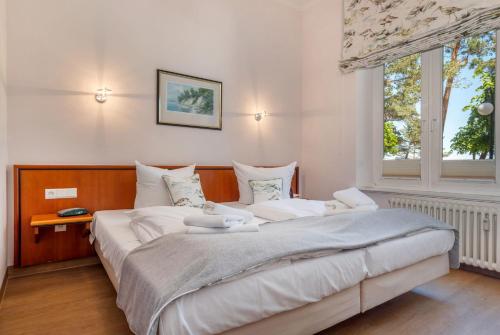 a bedroom with a large white bed with a window at Villa Elfeld Appartment 702 in Binz