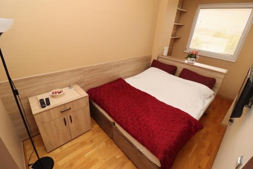 a small bedroom with a bed with a red blanket at Luxury Skopje Apartments Premium in Skopje