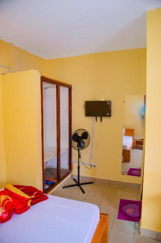 a bedroom with a bed and a tv in a room at HOTEL MAA MEVFOU Hmm in Yaoundé
