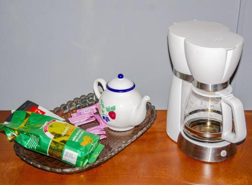 a coffee maker on a table next to a tea pot at HOTEL MAA MEVFOU Hmm in Yaoundé