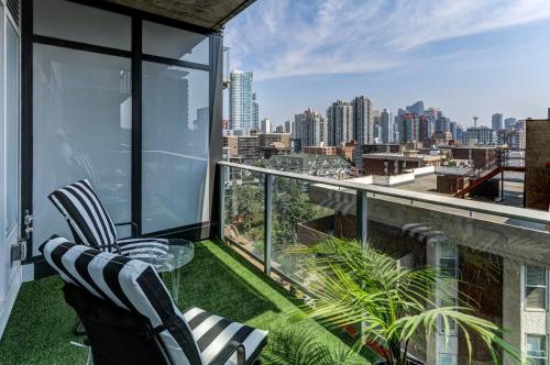 a balcony with two chairs and a view of the city at Boutique Studio City Views, Patio, Fireplace Voglio Bene in Calgary