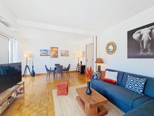 un salon avec un canapé bleu et une télévision dans l'établissement Nestor&Jeeves - TROPI AZUR - Terrace - Place du Pin, à Nice