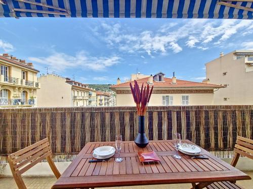 d'une table en bois avec un vase sur le balcon. dans l'établissement Nestor&Jeeves - TROPI AZUR - Terrace - Place du Pin, à Nice