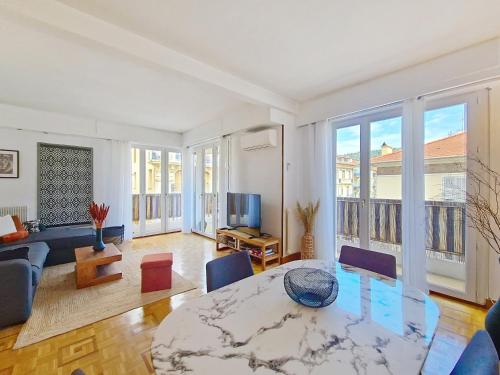 un salon avec une table et une télévision dans l'établissement Nestor&Jeeves - TROPI AZUR - Terrace - Place du Pin, à Nice