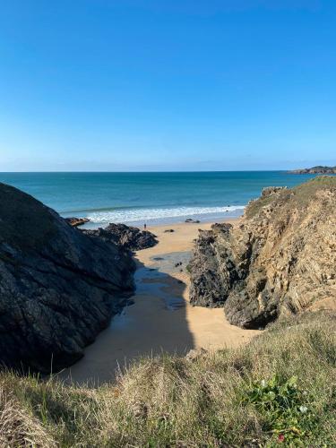 a beach with some rocks and the ocean at L'Écume Du Pouldu in Clohars-Carnoët