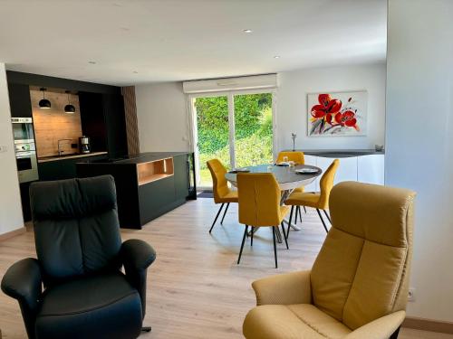 a kitchen and living room with a table and chairs at L'Écume Du Pouldu in Clohars-Carnoët