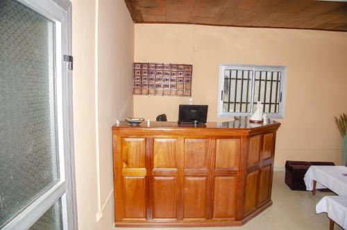 a room with a wooden cabinet with a laptop on it at HOTEL MAA MEVFOU Hmm in Yaoundé