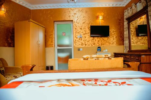 a bedroom with a bed and a sink and a mirror at Beaco Resort in Mbeya