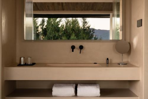Un baño con lavabo y ventana. en Lijiang Snow Mountain stone house, en Lijiang