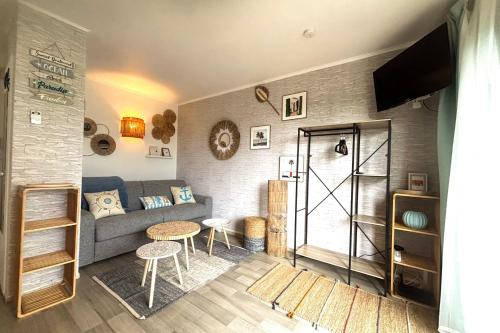 un salon avec un canapé et une table dans l'établissement La Perle Bleue - Proche plage - Parking - Terrasse, à Argelès-sur-Mer
