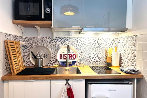 un comptoir de cuisine avec un évier et un micro-ondes dans l'établissement La Perle Bleue - Proche plage - Parking - Terrasse, à Argelès-sur-Mer
