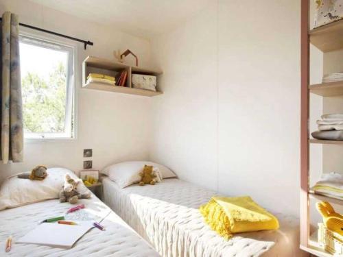 deux lits jumeaux dans une chambre avec fenêtre dans l'établissement Camping 4 étoiles - Piscine - eehafi, à Grayan-et-lʼHôpital