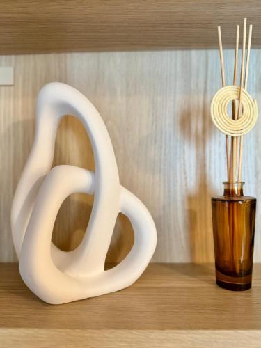 une sculpture blanche à côté d'un vase avec des baguettes dans l'établissement Le Petit Saint Georges, Hyper centre de Rennes, à Rennes