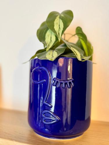 un vase bleu avec une plante sur une table dans l'établissement Le Petit Saint Georges, Hyper centre de Rennes, à Rennes
