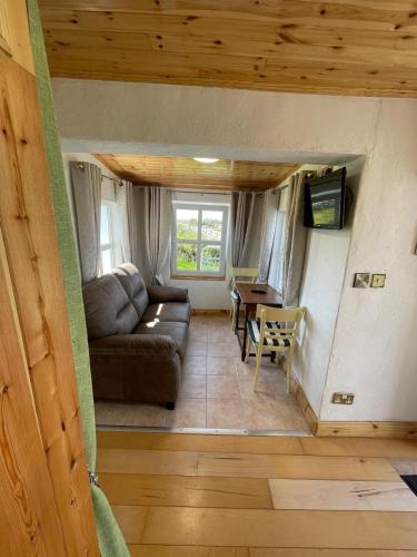 a living room with a couch and a table at Calla Roundstone in Roundstone