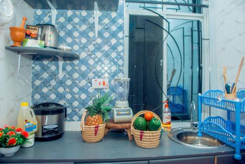 a kitchen counter with baskets of fruit and a sink at Serengeti in Mbeya