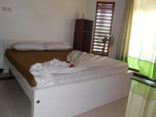 a bed in a room with a white mattress at Bee Nest Bed & Breakfast in Negombo