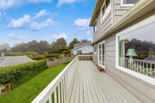a white house with a deck with a window at Ocean View Terrace in Lincoln City