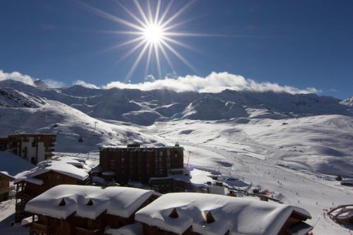 a snow covered mountain with the sun in the sky at Hotel 3 Vallées Val Thorens in Val Thorens
