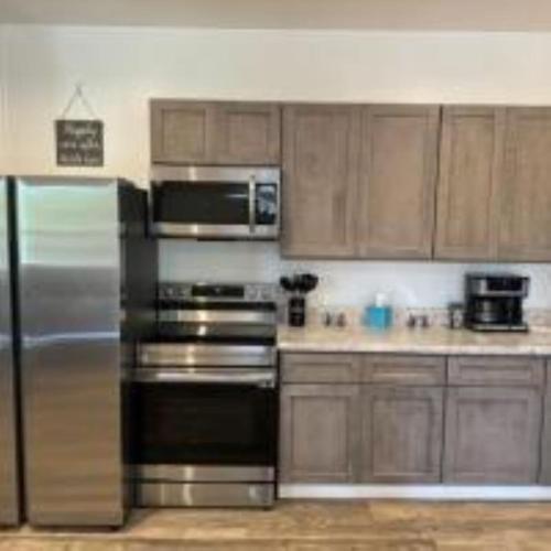 a kitchen with stainless steel appliances and wooden cabinets at The Murphy in Sutton