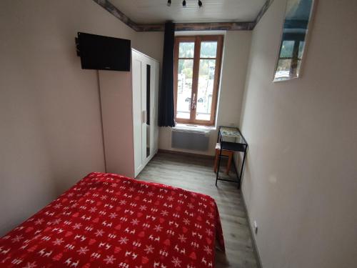 - une chambre avec un lit rouge et une fenêtre dans l'établissement Appartement Au Cœur du Village, à Le Mont-Dore