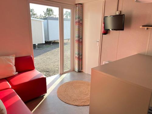 a living room with a red couch and a sliding glass door at Padel Camp House in Cascais