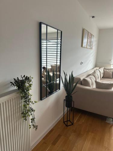 a living room with a couch and a mirror at ZORA apartmani Sarajevo in Sarajevo