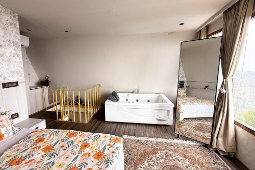 a bedroom with a bed and a mirror and a tub at Himadvaya- The Himalayan Prism in Almora