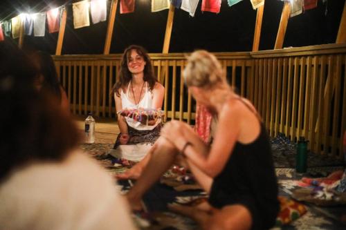a woman sitting on the floor with a woman holding a cake at Bliss House in Tom Town