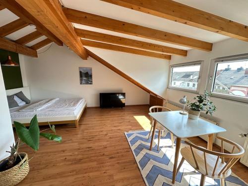 a bedroom with a bed and a table in a room at Cozy loft with a view, central, close to tradefair in Düsseldorf